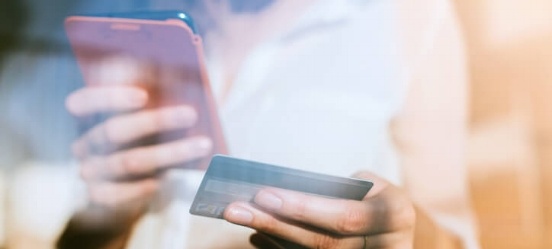 Iemand controleert creditcardbetalingen op een smartphone