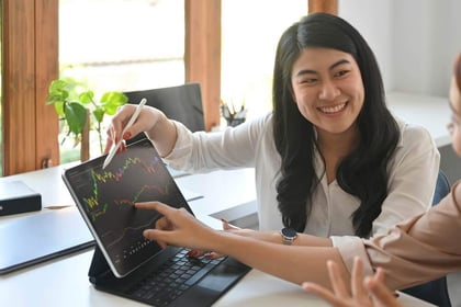 Vrouw legt koersgrafiek uit van AEX